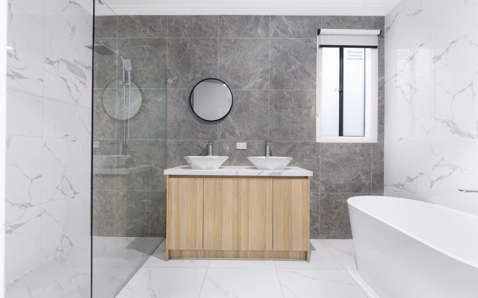 Modern saniertes Badezimmer mit Naturstein-Fliesen und Holz-Waschtisch