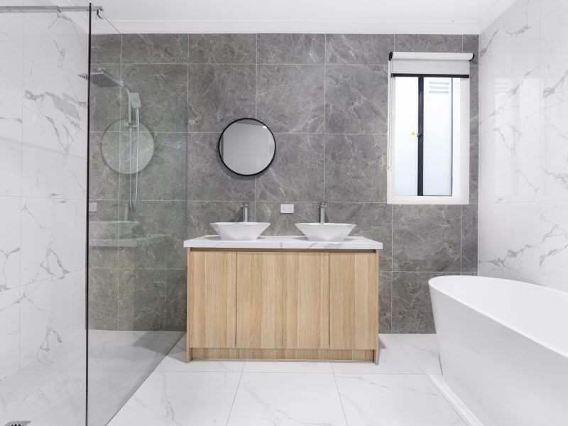 Modern saniertes Badezimmer mit Naturstein-Fliesen und Holz-Waschtisch